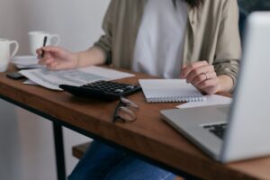 Freelancer calculating self-employment tax deductions with organized financial records